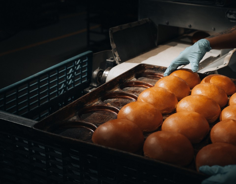 Hands placing brioche on a tray